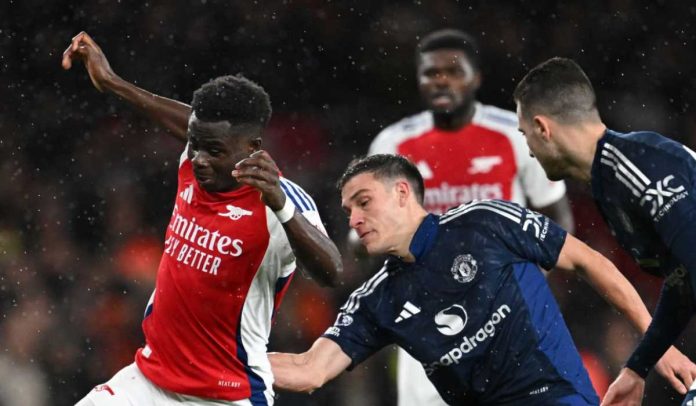 Manuel Ugarte berusaha menghentikan Bukayo Saka di laga Arsenal v Manchester United