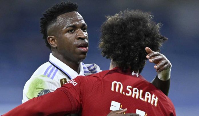 Vinicius Junior memeluk Mohamed Salah dalam pertemuan Liverpool vs Real Madrid